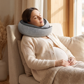 Pregnant woman dozing upright wearing the memory foam travel neck pillow