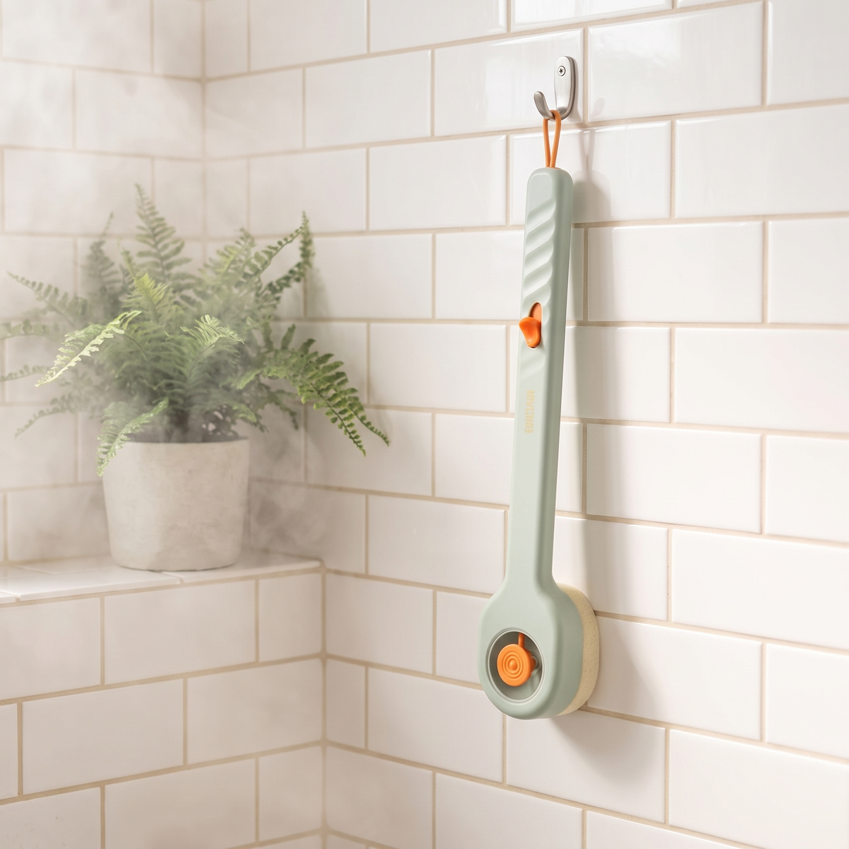 Long handled back brush hanging on a hook in a bright shower