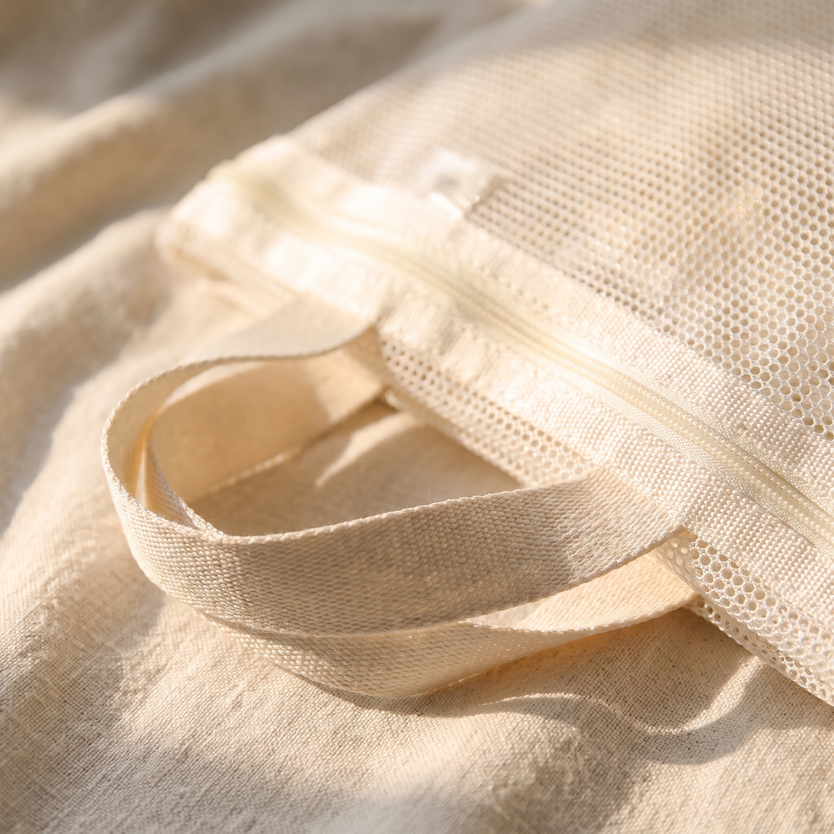Close-up of the breathable mesh and handle loop of the shower bag